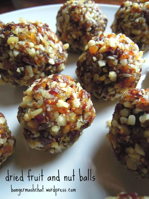 a white plate topped with lots of fruit and nut balls