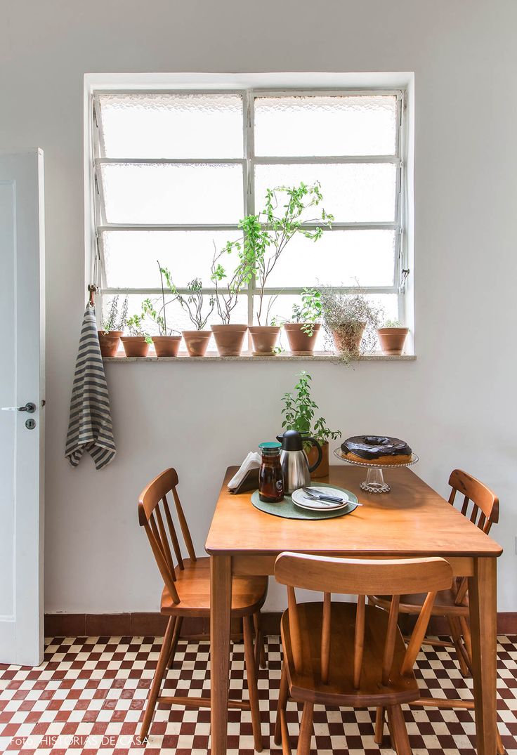 a kitchen table with two chairs and a potted plant