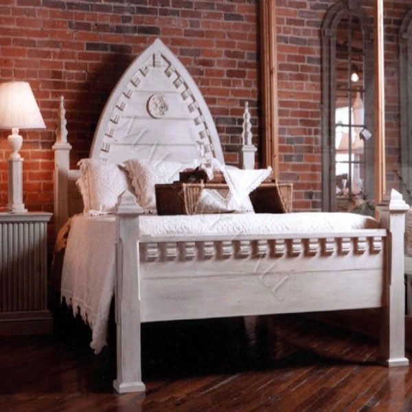 a white bed sitting on top of a hard wood floor next to a brick wall