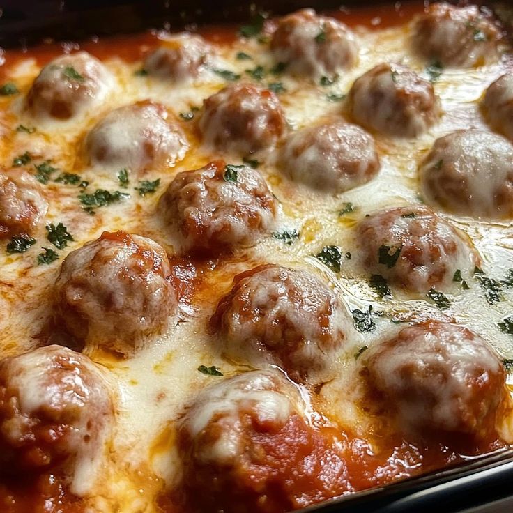 a casserole dish filled with meatballs and cheese