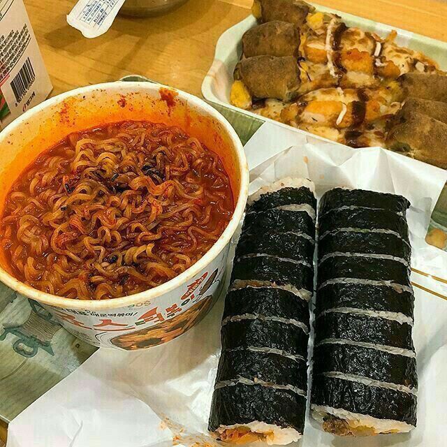 there are many different foods on the table including noodles, meats and rice rolls