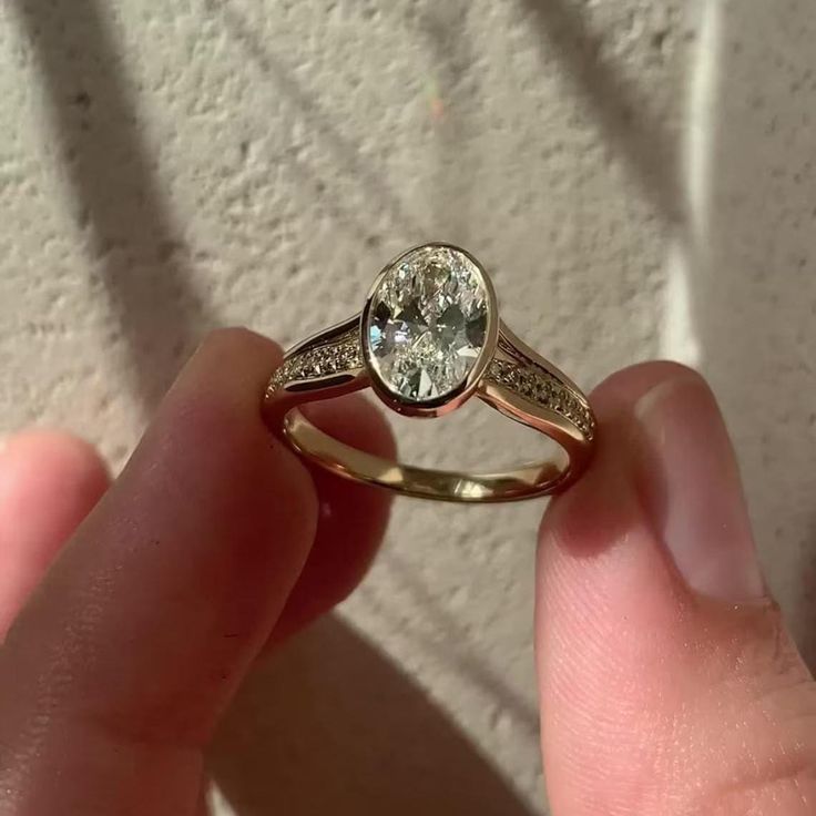 a person holding a ring with a diamond in it's center and two diamonds on the side