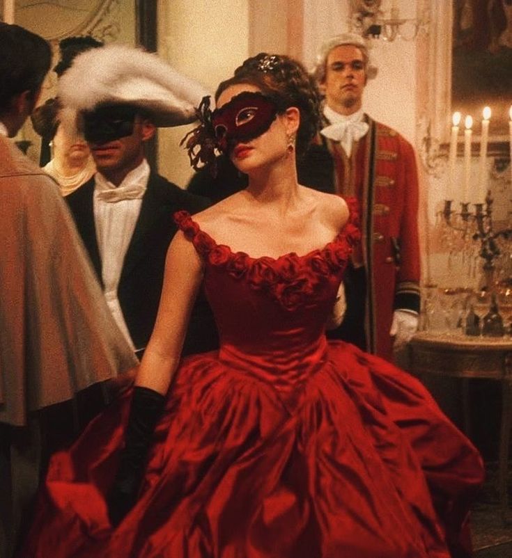 a woman in a red dress with a mask on