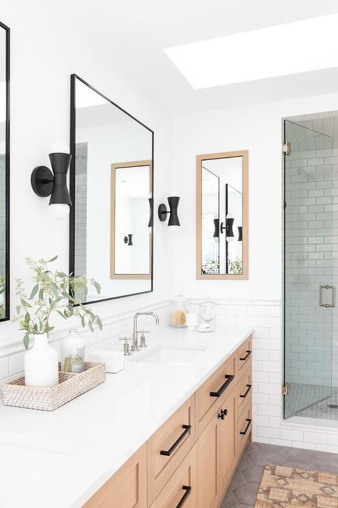 a bathroom with two sinks and mirrors on the wall