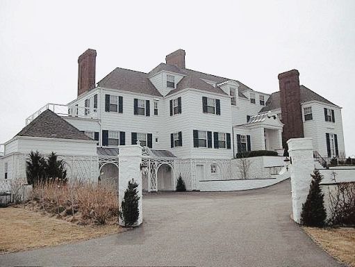 a large white house sitting on top of a lush green field