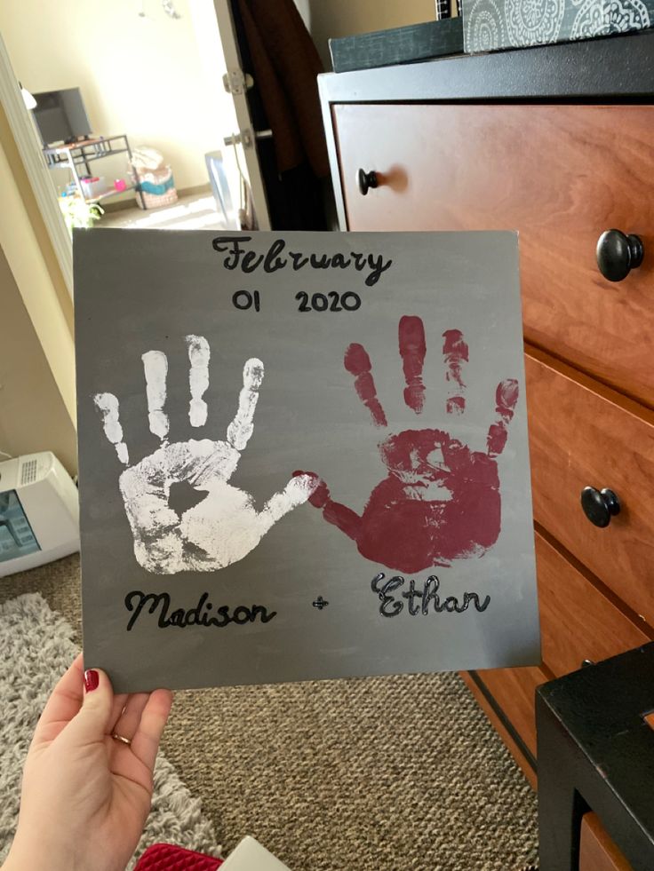 a child's hand and foot prints are displayed on a sign in front of a dresser