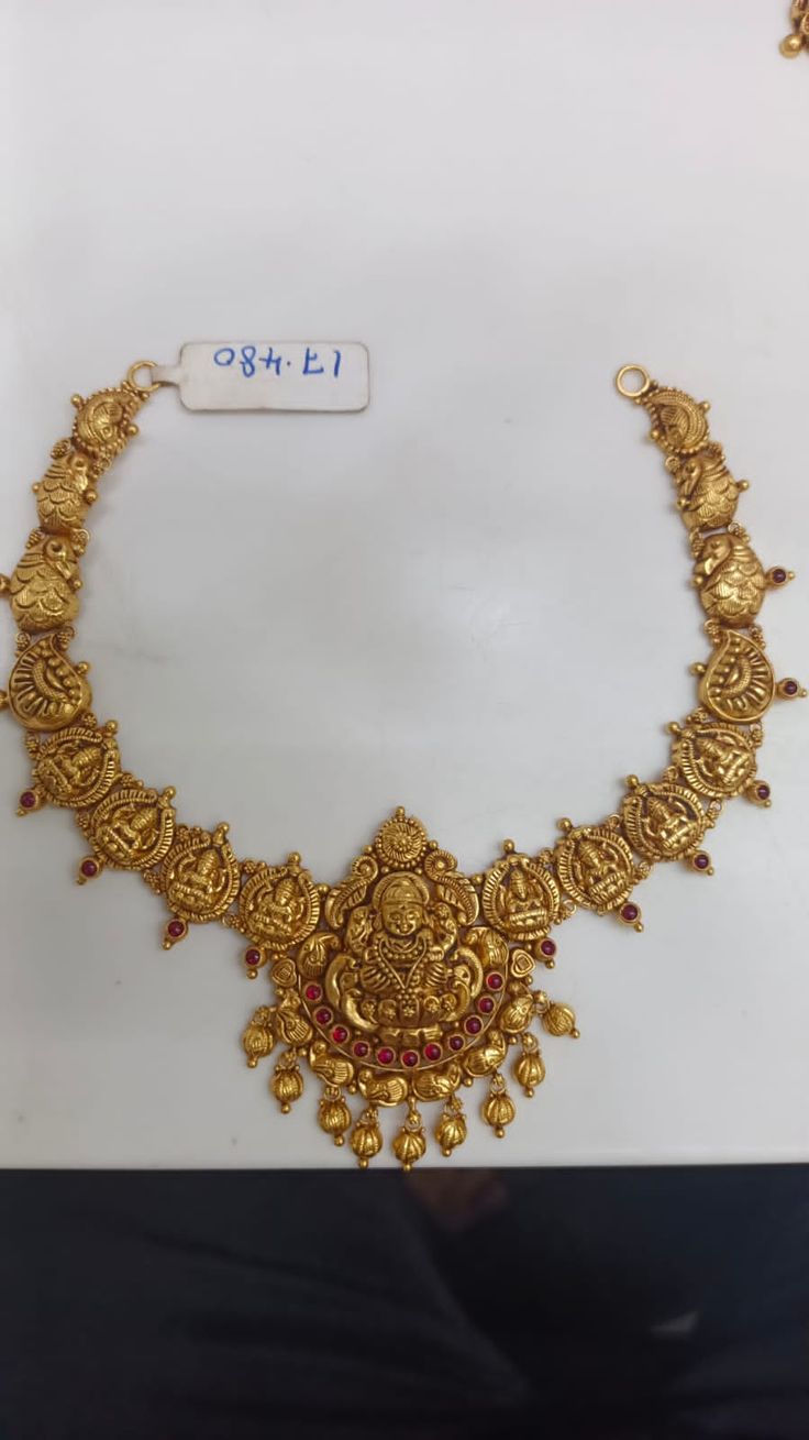 an ornate gold necklace with red stones