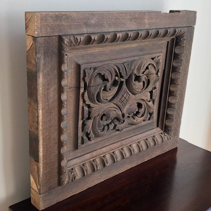 an ornate carved wooden frame on top of a table