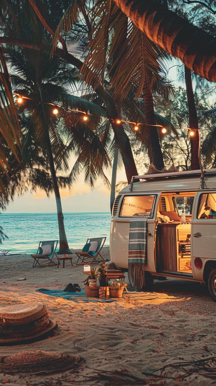 an old vw bus parked on the beach with lights strung from it's roof