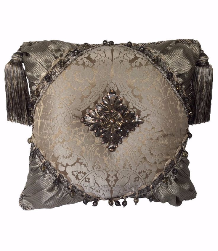 a decorative pillow with tassels on the sides and an ornate design on the back