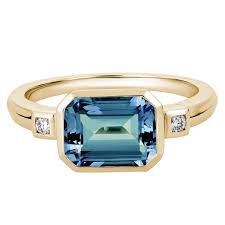 Emerald Cut Blue Topaz Ring with Diamond Side Stones in Yellow Gold | Borsheims Blue Topaz Jewelry, Colored Stone Rings, Emerald Cut Rings, Topaz Engagement Ring, Topaz Jewelry, London Blue Topaz Ring, Swiss Blue Topaz, Yellow Gold Ring, Blue Topaz Ring