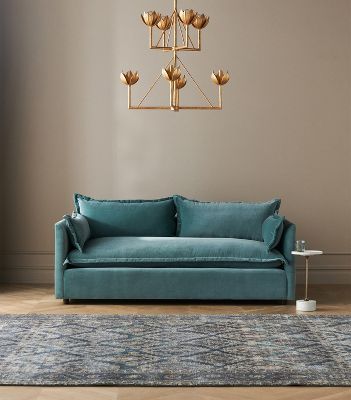 a living room with a blue couch and gold chandelier