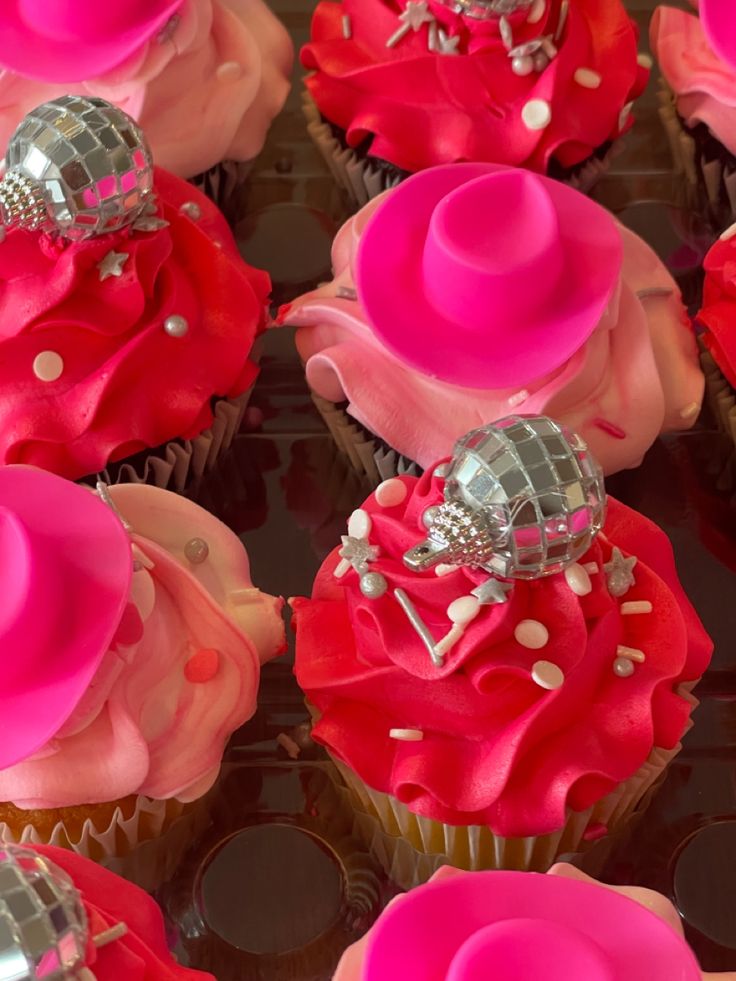 cupcakes decorated with pink and red frosting, topped with a top hat