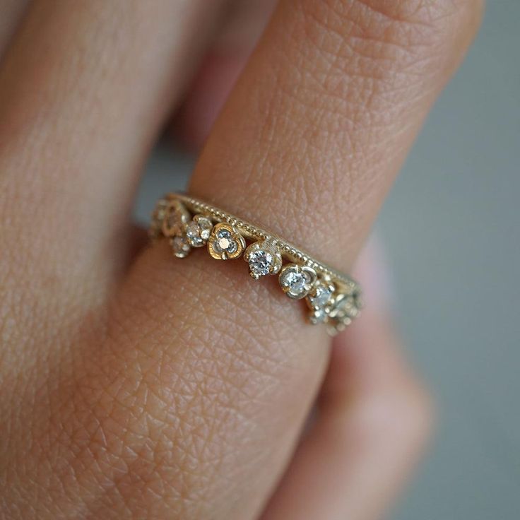 a woman's hand with a diamond ring on her left side and the other half of her finger