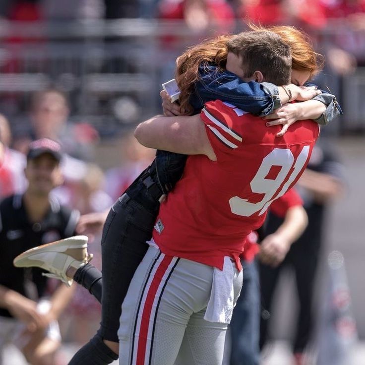 two football players hugging each other on the field