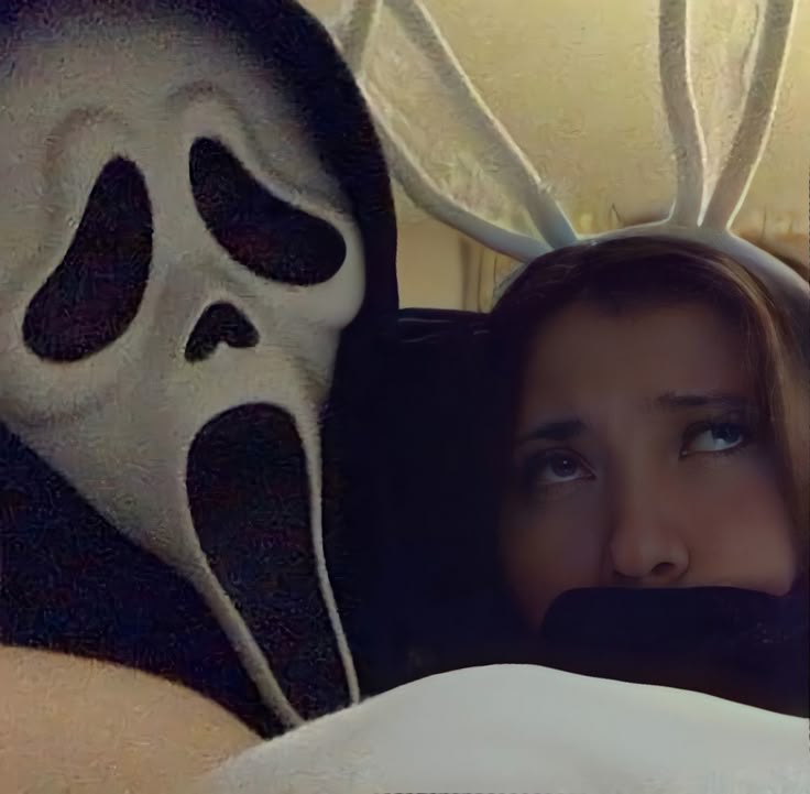 a woman laying in bed with a mask on her face