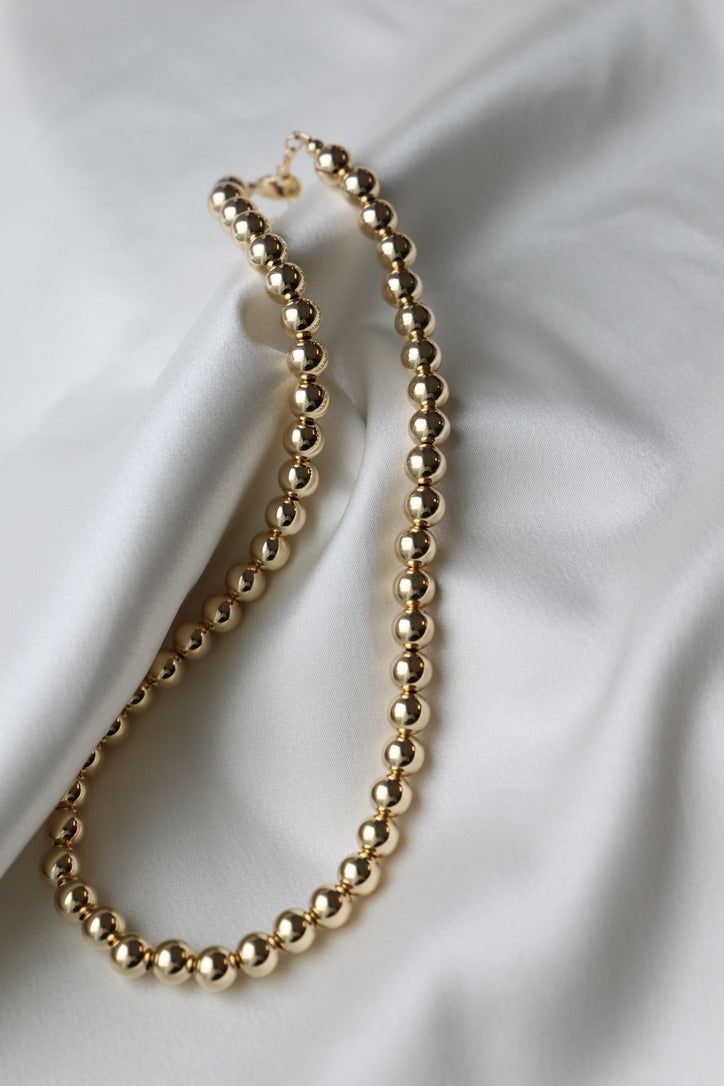 Comprised of our highest quality materials, this piece features 8MM gold filled beads making it the perfect statement piece in your collection that pairs beautifully with our other gold styles. Materials: Gold filled beads and lobster Length: 16-18" SKU: N1104GOLD Materials+Care Elegant Gold Chain Necklace With Polished Beads, Elegant Gold Beaded Necklace With Large Beads, Elegant Gold Beaded Necklace With Spacer Beads, Elegant Gold Necklaces With Round Beads, Formal Gold Chain Necklace With Beads, Classic Gold Choker Necklace, Elegant Gold Necklace With Round Beads, Gold Single Strand Choker Necklace, Elegant Ball Chain Choker