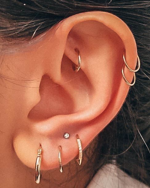 a close up of a person's ear with three different types of piercings