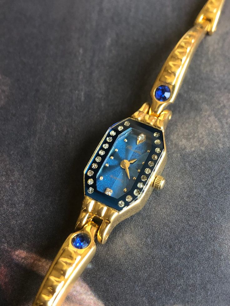 Chinese Shanghai Vintage Quartz Watch for women The sapphire blue dial echoes the blue rhinestones on the bracelet, a very unique design, small and exquisite Baoshihua is a brand from a Shanghai watch factory in the 70s-90s. Before the 1990s, the watches existing in Shanghai Watch Factory were all manual mechanical watches, but in the subsequent development of internationalization, the quartz watch movement was slowly introduced, and then the Japanese quartz watch movement was slowly used, such as this watch This is a never-before-worn vintage watch in very good condition. New battery is fitted, and working perfectly. Length:18.3cm Width: 12cm (crown excluded) Enjoy your shopping! Elegant Analog Jewelry And Watches For Gifts, Gold Stainless Steel Diamond Watch As Gift, Elegant Gold Diamond Watch As Gift, Analog Stainless Steel Jewelry And Watches As Gift, Gold Diamond Watch In Stainless Steel As Gift, Gold Diamond Watch With Jubilee Bracelet As Gift, Gold Diamond Watch As A Gift, Gift Jewelry With Diamond Hour Markers And Round Dial, Elegant Metal Jewelry And Watches For Gifts