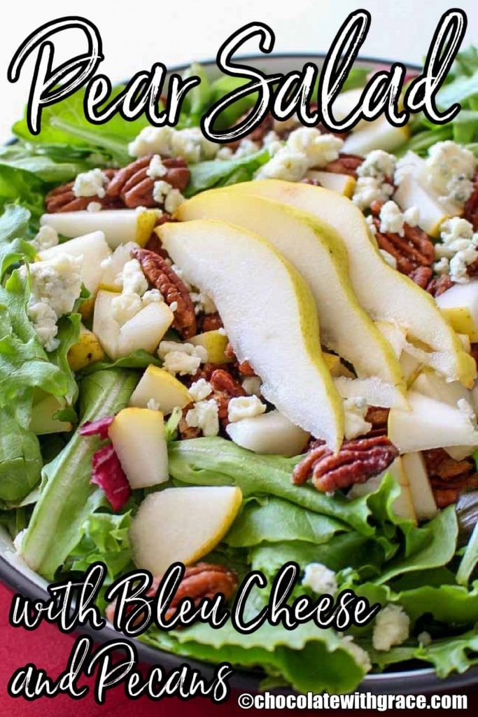 pear salad with red cheese and pecans in a bowl on top of a table