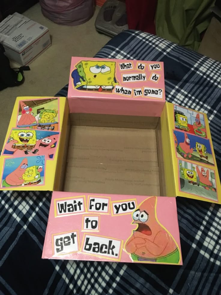 an open box with the simpsons characters on it sitting on top of a bed next to other boxes