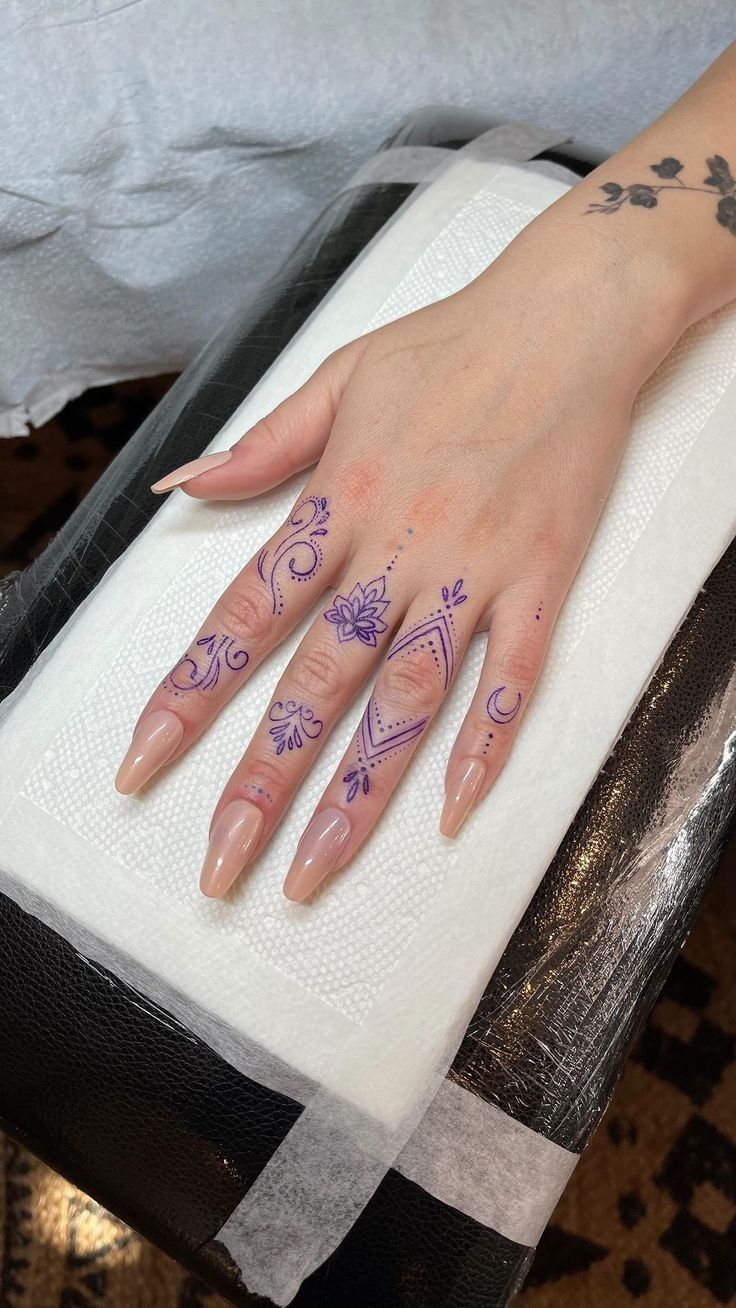 a woman's hand with purple ink on her left hand, sitting on top of a mattress