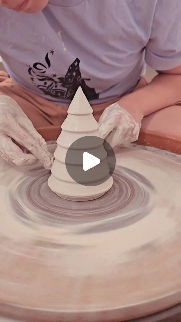 a woman is making a vase out of clay