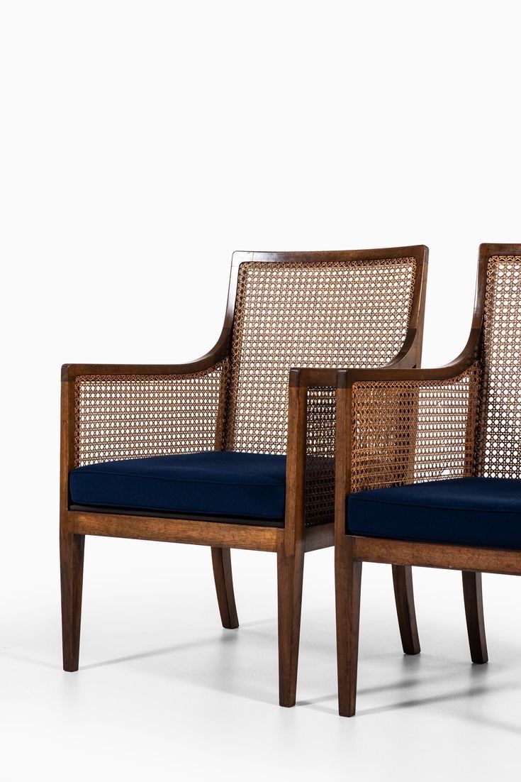 two wooden chairs with blue cushions sit side by side