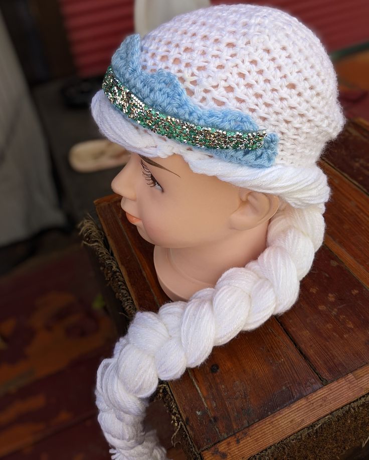 a white wig with braids and a blue hat on top of a wooden table