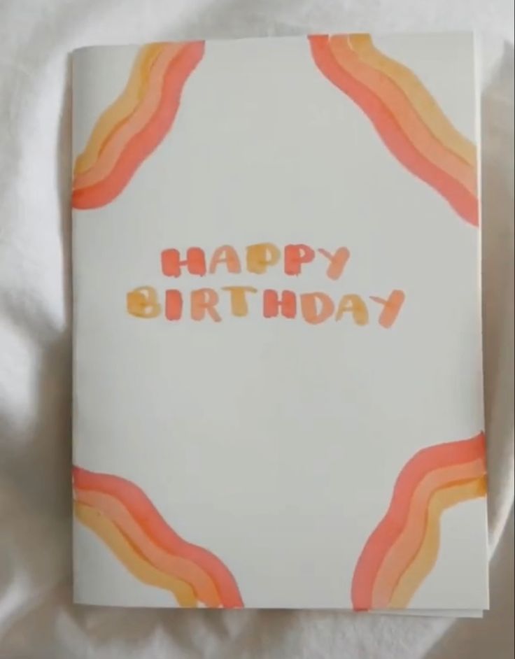 a birthday card with the words happy birthday written in orange and pink on white paper