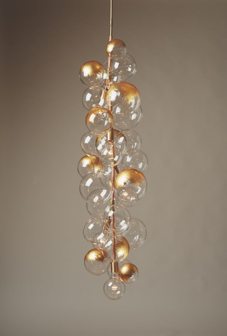 a chandelier with glass balls hanging from it's sides and gold accents