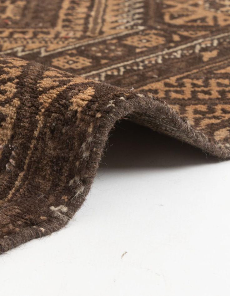 a brown and tan area rug on a white surface