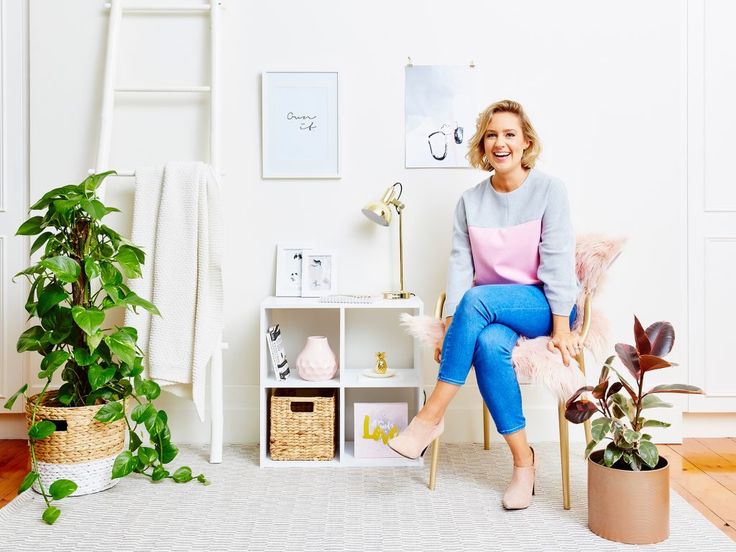 a woman sitting on a chair in front of a potted plant and other plants