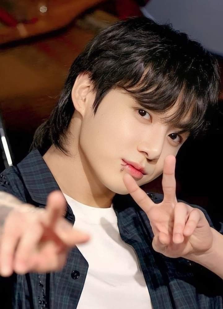 a young man making the peace sign with his fingers