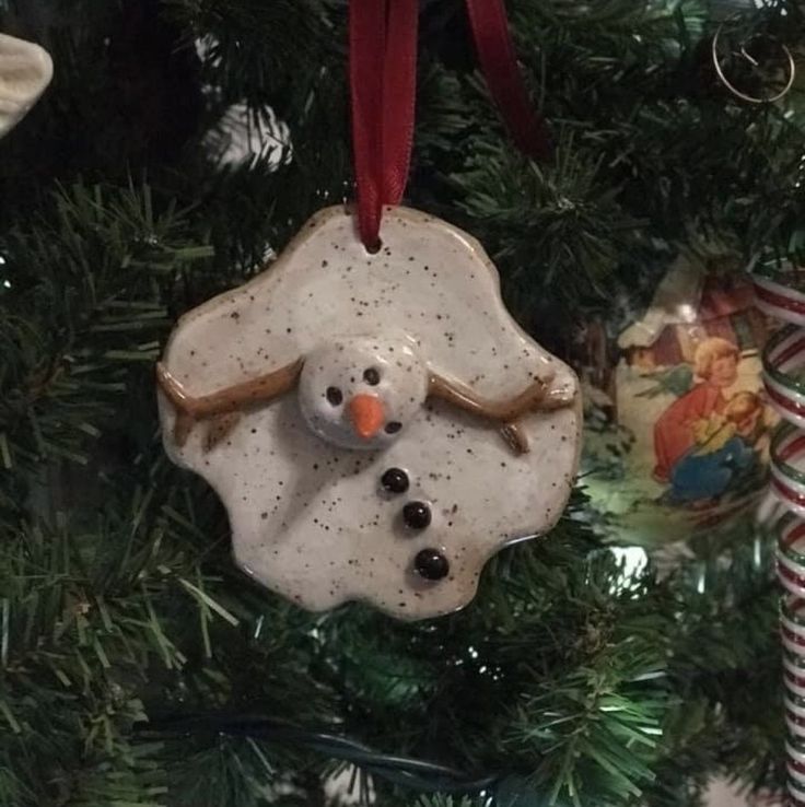 a snowman ornament hanging from a christmas tree