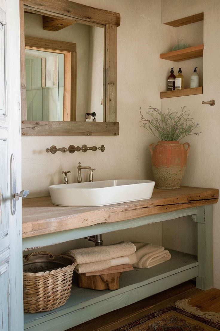 a bathroom sink sitting under a mirror next to a wooden shelf with baskets on it