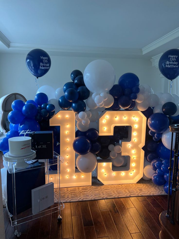 a room filled with balloons and lights that spell out the number fifteen