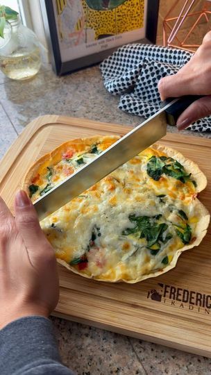 a person cutting up food on top of a wooden cutting board with a large knife