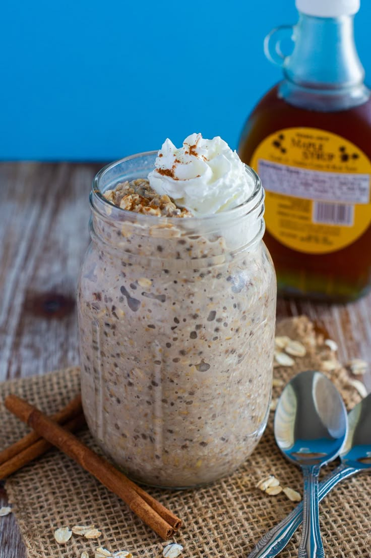 french toast overnight oats in a mason jar with cinnamon sticks and spoons next to it