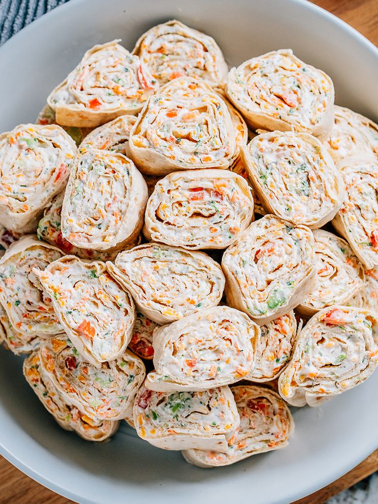 a white bowl filled with lots of different types of food on top of a wooden table