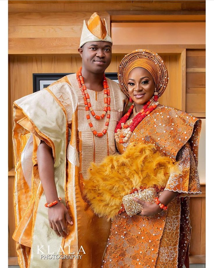 a man and woman dressed in traditional african garb posing for a photo with each other