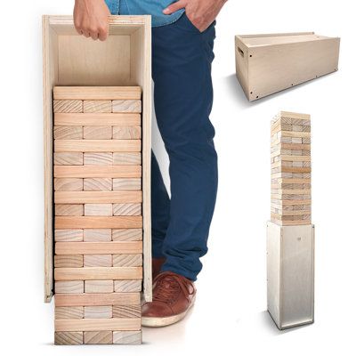 a man standing next to a stack of wooden blocks and a cardboard box with the lid open