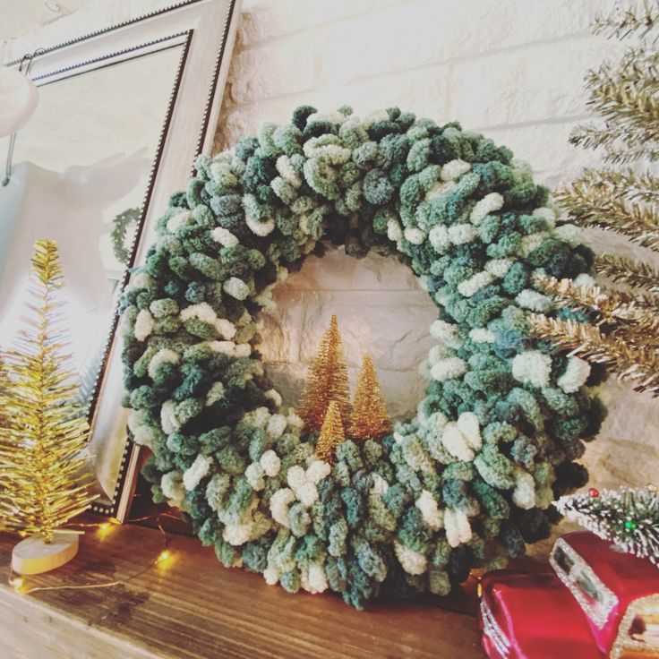 a christmas wreath sitting on top of a mantle