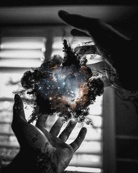 two hands holding something in front of a window with the sky and stars above them