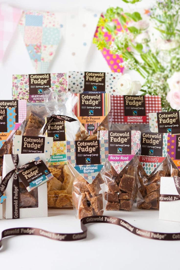 several bags of dog treats on a table with flowers and bunting streamers in the background