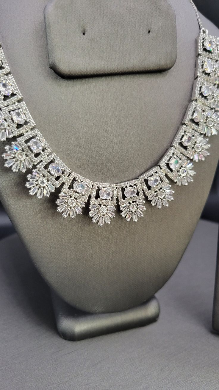 A beautifully crafted American Diamond necklace set with rhodium plating. Clear, intricate stone work. American Diamond Necklace Set, American Diamond Necklaces, Diamond Pendant Sets, Diamond Necklace Set, Diamond Dangle Earrings, Jewellery Sets, Kundan Necklaces, Diamond Bangle, Stone Work