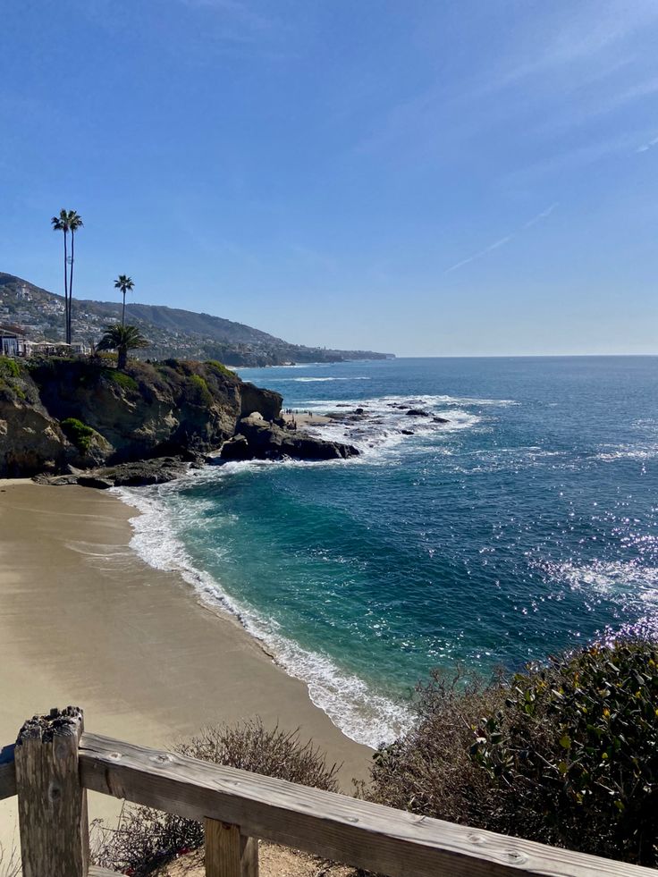 the beach is next to some water and palm trees