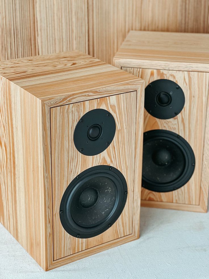 two wooden speakers sitting next to each other