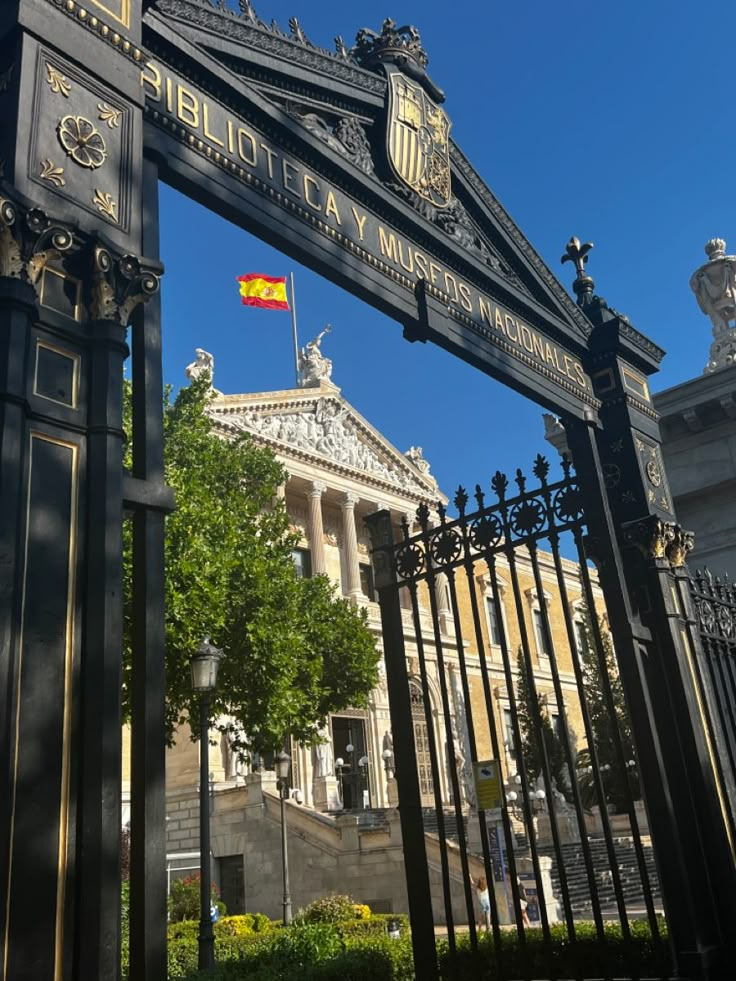 an iron gate in front of a building with a flag on it