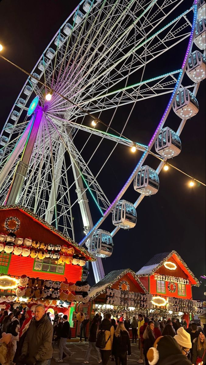 the ferris wheel is lit up at night